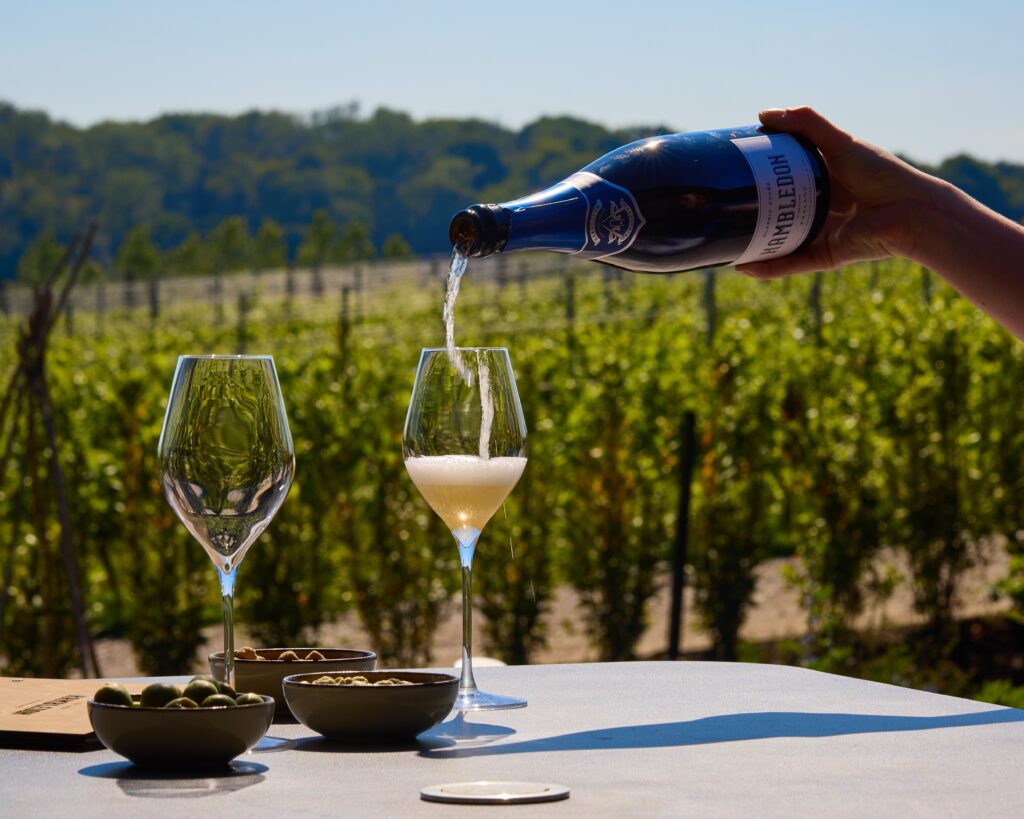 A bottle of Hambledon Vineyard Classic Cuvee being poured.